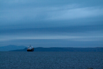 A boat in the middle of the sea in the blue of the dusk