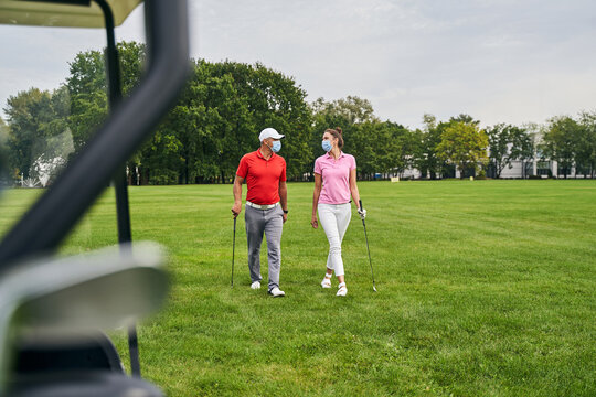 Two Adult Golfers Wearing Disposable Face Masks