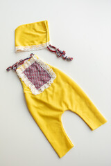 Combed cotton clothes and newborn hats of various colors and types on a white background.