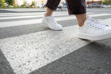 female feet crossing the crosswalk