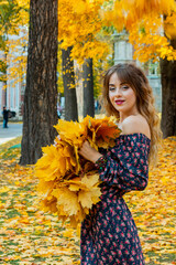 Beautiful girl with autumn leaves. October photos of autumn.