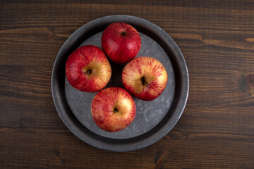 Apples in a metal plate. Healthy diet, vitamins and antioxidants concept. Dark wooden background