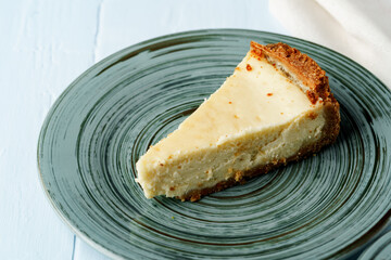 Piece of classic cheesecake on green plate