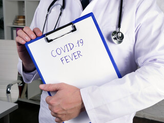Medical concept meaning COVID-19 FEVER with phrase on the page.
