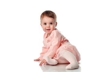 Adorable little baby girl smiling, sitting on the floor, studio shot, isolated on white