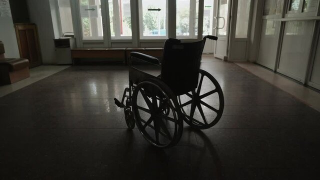 Approaching an empty wheelchair sitting in an empty hospital corridor