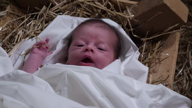 4K Gimbal: Baby Jesus laying in a Manger with straw and Hay. Christmas Nativity Scene in the stable. Top View