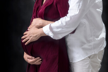 Pregnant couple touching belly with hand