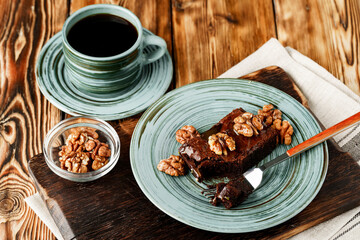 Piece of chocolate cake with nuts on green plate