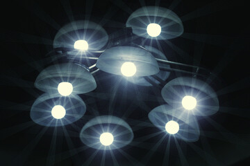 starry effects of the bulbs in a modern chandelier on the wall  in the night