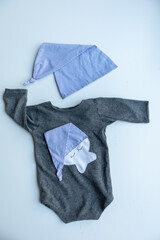 Combed cotton clothes and newborn hats of various colors and types on a white background.