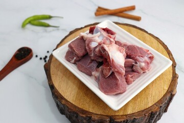 Fresh raw goat meat or mutton or lamb pieces. Preparation for Indian mutton curry. Spice at the...