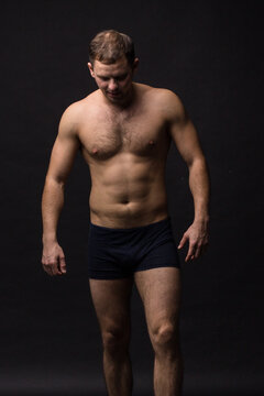 Handsome man in underwear on the black background. Muscular and athletic. 
Underwear man portrait. Male underwear model in studio
