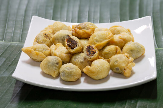 Fried flour molding thai ancient dessert which has fish filling stuffed, (Thai called "Pan klib") in white dish on banana leaf