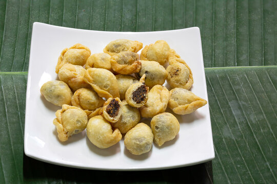 Fried flour molding thai ancient dessert which has fish filling stuffed, (Thai called "Pan klib") in white dish on banana leaf