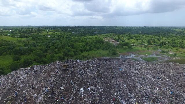Multitude of people searching through garbage in Duquesa landfill. Aerial forward