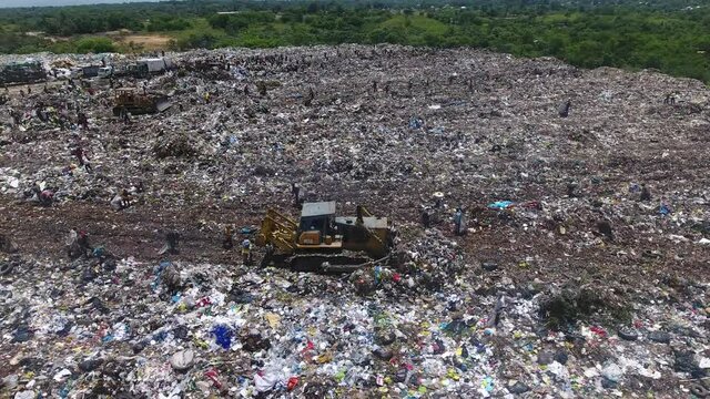 Bulldozers push waste at Duquesa landfill, Santo Domingo. Aerial circling