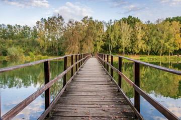 Fototapeta na wymiar An old wooden bridge at Lake Gebart (Gebarti-to) in Zalaegerszeg, Hungary