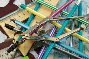 A variety of stationery in a chaotic mess are spread out on the table, background - obrazy, fototapety, plakaty