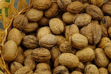 Walnuts lie in a wicker basket, background