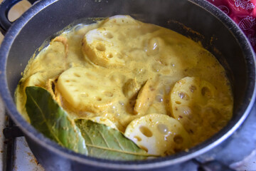 cooking yellow green curry with lotus root and spices