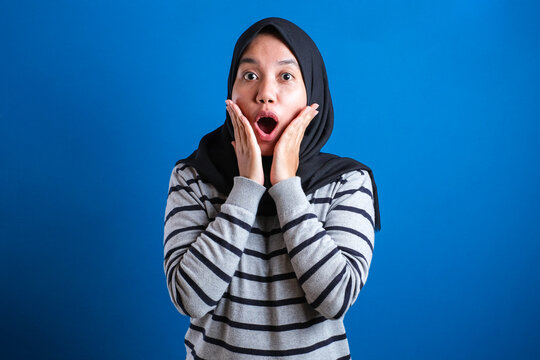 Portrait of cute young Asian muslim college student girl wearing hijab shows surprised or shocked expression