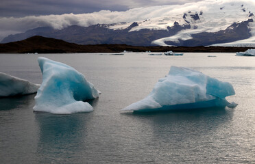 Melting glaciers climate change concept. Dramatic image of icebergs in Jokulsarlon lagoon at the evening. South Iceland.