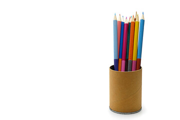 Group of coloured pencils in a cardboard glass on a white background on the right side of the frame.