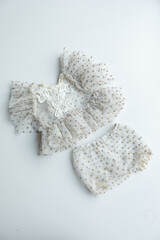 Combed cotton clothes and newborn hats of various colors and types on a white background.