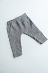 Combed cotton clothes and newborn hats of various colors and types on a white background.