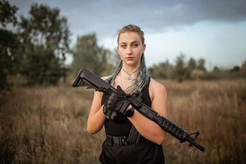 Sexy woman posing with rifle at outdoor