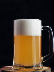 Glass mug of wheat foam beer on a dark background