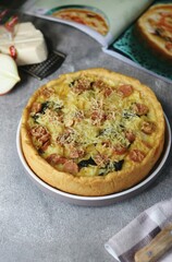 Quiche Lorraine, French tart made from pastry crust,milk, cheese, sausage and vegetables. Wooden textured background.