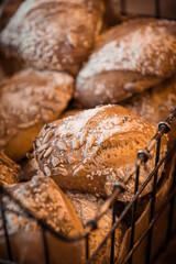 Warm fresh baked homemade bread buns with seeds on top in a metal basket