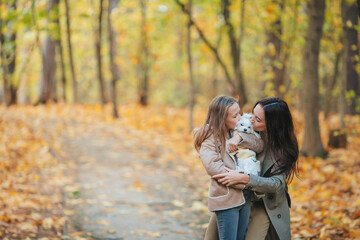 Fototapeta premium Little girl with mom outdoors in park at autumn day