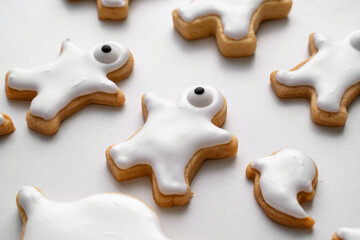 Obraz premium Close up of decorating cute Halloween cookies with frosting in icing bag.
