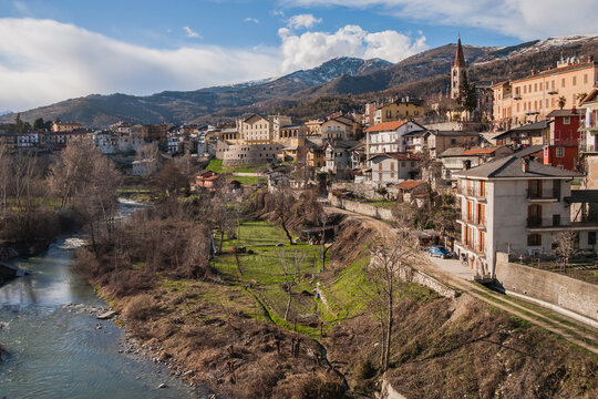 Dronero town and river with snow on the mountains scenic view in Cuneo Province, Piedmont, Italy