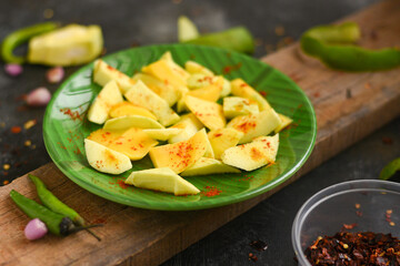 Sliced green mango with chili powder , salt street food snack Kerala. Organic Fresh mango table salt mixed with ground chilli . Indian Traditional Raw Mango Pickle. Bengali seasonal fruit unripe mango