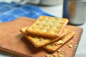 Cracker and coffee on the wooden chopping board on the table