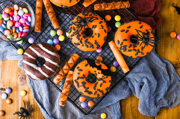 Halloween donuts on a wooden background. Sweet pastries decorated for a horror party. Copy space. Top view. High quality photo