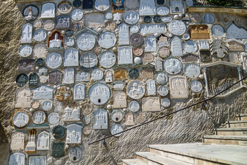 Wall storage with ground from different holy places in Assumption Cave Monastery, Bakhchysarai, Crimea. Steps on right side are leading up to main church