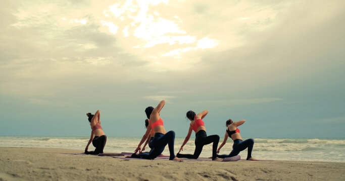 Professional group females yoga practice in class on mat stretching