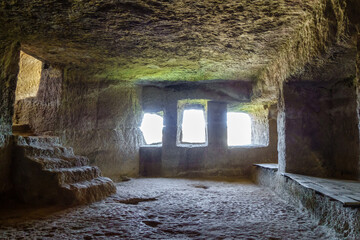 Room with stairs & windows inside ancient cave city Chufut Kale, Bakhchisaray, Crimea. Boards on...