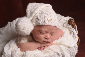 Fototapeta na wymiar Cute infant Newborn baby in a knitted hat on a blanket. Portrait of newborn baby. Face of sleeping small child 