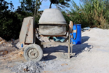 Dirty concrete mixer at a construction site. Construction equipment.