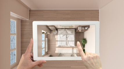 Augmented reality concept. Hand holding tablet with AR application used to simulate furniture and design products in empty interior with parquet, eco bedroom top view, plan, above