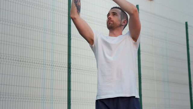Young male is playing basketball outside