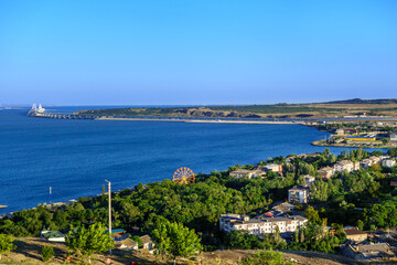 Fototapeta na wymiar Panorama of Kerch, Crimea. There are park of attractions & residential houses. Crimean bridge & railroad are on background