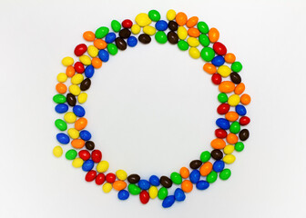 Circle of colored chocolate round candies. Space for text. Top view, flat lay