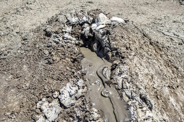 Close up view in crater of mud volcano. There is slow flow of volcanic mud (mix of oil, water & other liquids)